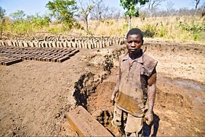 27-letni robotnik po przesiedleniu do Mwaladzi wyrabia cegły w zamian za paczki żywnościowe od koncernu